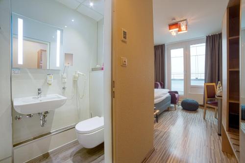 La salle de bains est pourvue d'un lavabo, de toilettes et d'un lit. dans l'établissement City Hotel Hannover, à Hanovre