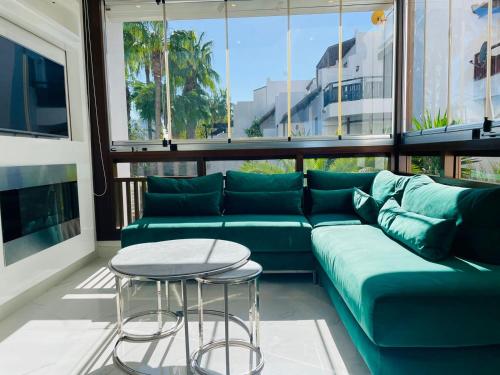 a living room with a green couch and a table at Ksar Rimal par IMMO MARINA Vacances de Rêve J in Marina Smir