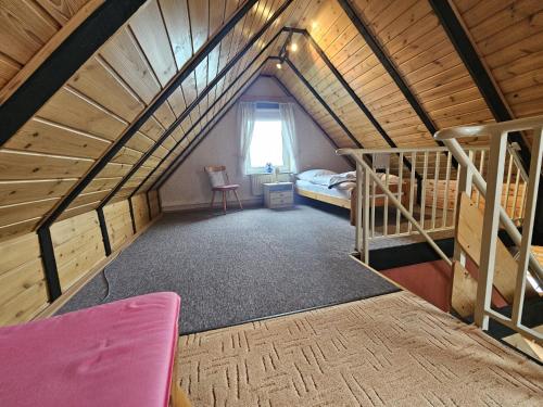 a attic room with a bed and bunk beds at Reimann's Ferienwohnungen in Emden