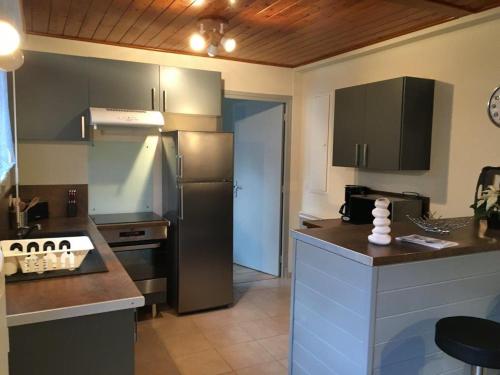 une cuisine avec un réfrigérateur en acier inoxydable et un comptoir dans l'établissement Coups de Cœur à Saint Lary maison 4/6 Personnes ***, à Saint-Lary-Soulan