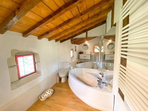 baño blanco grande con bañera y aseo en Mas des eaux claires Arles Camargue, en Saint-Gilles