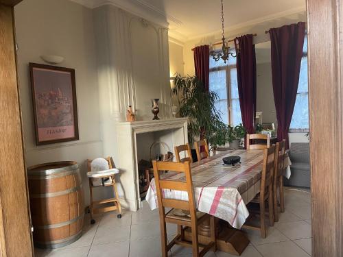 een eetkamer met een tafel en een wijnvat bij Le gite berguois in Bergues