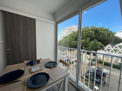 - une table à manger avec vue sur un balcon dans l'établissement Le Palais MAYA - Lumineux - Wifi, à La Grande Motte
