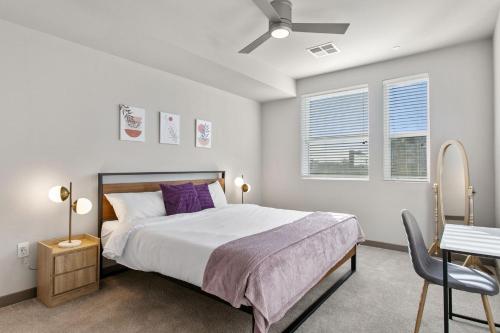 a bedroom with a bed and a table and a chair at Cozysuites PHX RORO Gym, Pool, Pets, Parking! #3 in Phoenix
