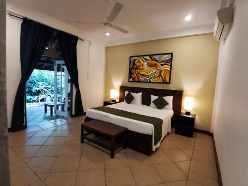 - une chambre avec un lit et une peinture murale dans l'établissement The Villa Green Inn, à Negombo