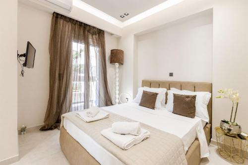 a white bedroom with a large bed with towels on it at Vivian's Luxury Suite in Monemvasia