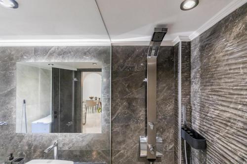 bagno con lavandino e specchio di Vivian's Luxury Suite a Monemvasía