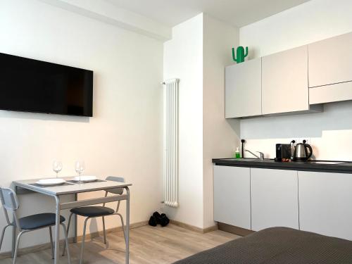 una cucina con armadi bianchi e tavolo con sedie di Centro Storico e Piazze - Free WiFi - Suite Antenore Deluxe a Padova