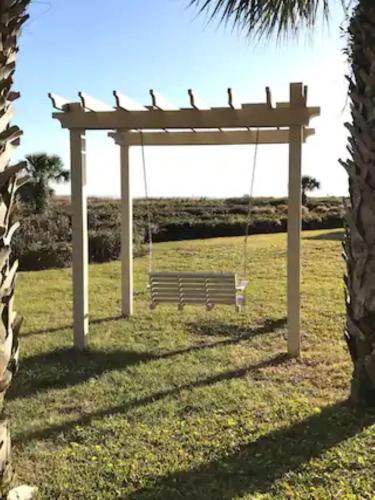 a swing in a park with a tree at Beachfront Condo with Ocean View in Hilton Head Island