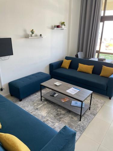 a living room with blue couches and a coffee table at Golden Stone Beach in Halat Byblos