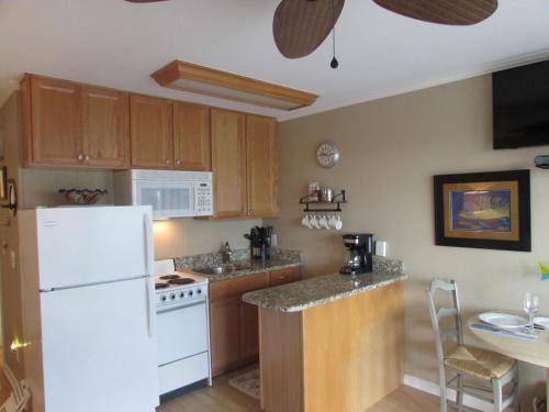 uma cozinha com um frigorífico branco e uma mesa em Beachfront Condo with Ocean View em Hilton Head Island
