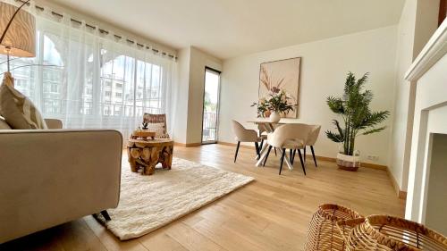 een woonkamer met een tafel en een eetkamer bij Appartement confortable entre Paris et Versailles in Ville-dʼAvray