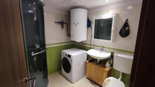 a bathroom with a washing machine and a sink at Andy's Apartman in Budapest