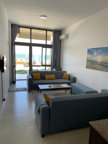 a living room with couches and a table at Golden Stone Beach in Halat Byblos