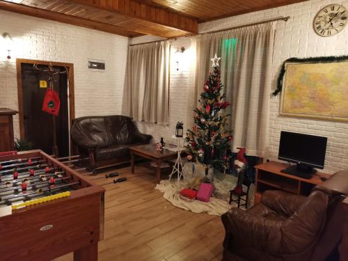 a living room with a christmas tree and a chess board at Хаджи Марковата къща за гости гр.Дряново in Dryanovo