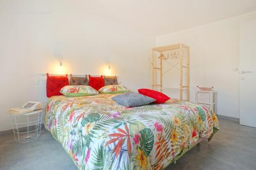 1 dormitorio con 1 cama grande y edredón colorido en Gîte de la Madeleine, en Landelies