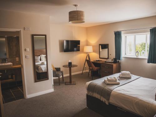 a hotel room with a bed and a desk at Crossways in Wells