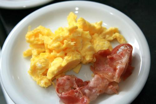 a plate of breakfast food with eggs and bacon at Kaulem Hotel Boutique in El Chalten
