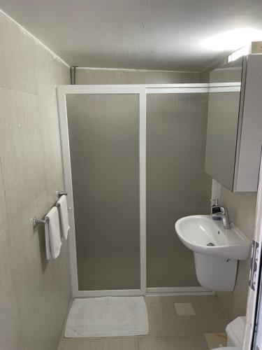 a bathroom with a shower and a sink and a toilet at Golden Stone Beach in Halat Byblos