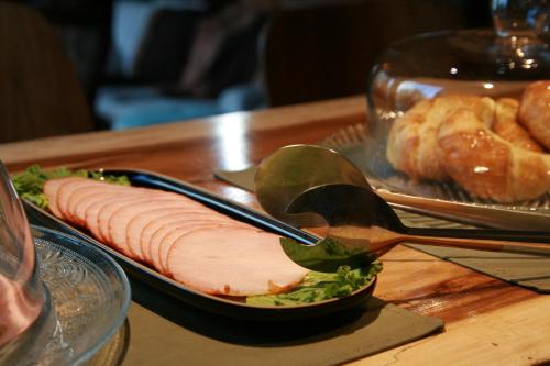 a piece of meat on a plate with a spoon at Kaulem Hotel Boutique in El Chalten