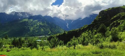 a view of a mountain valley with trees and mountains at Waterfall valley stay in Palchān