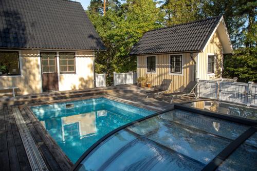 a swimming pool in front of a house at Villa Anna - SWEEDS Loftahammar in Loftahammar