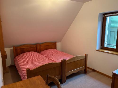 una camera con letto e piumone rosso di Auberge du Graber a Dolleren