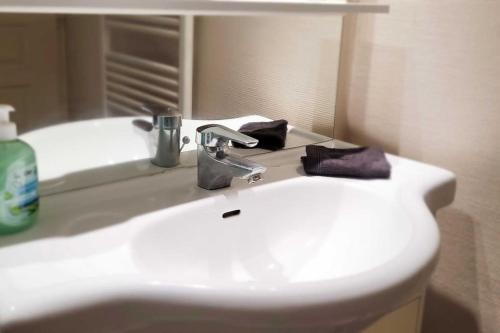 une salle de bain avec un lavabo blanc et un miroir dans l'établissement Le Saint André, à Montigny-lès-Metz