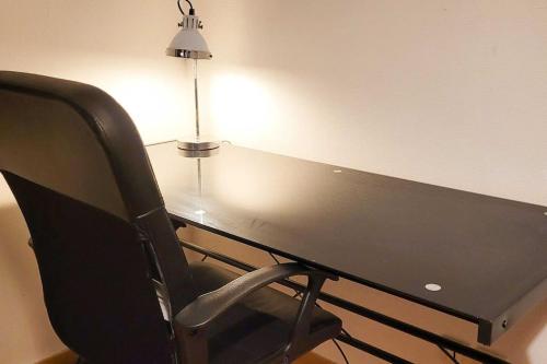 un bureau noir avec une chaise et une lampe dans l'établissement Le Saint André, à Montigny-lès-Metz