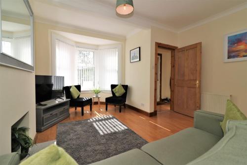 a living room with a couch and a tv at Signature - Lincoln View in Knightswood