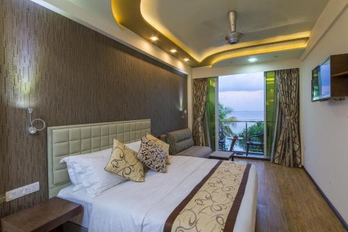1 dormitorio con 1 cama grande y balcón en Vista Beach Retreat, en Hulhumale
