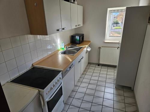 a small kitchen with a sink and a stove at FeWo3 Köthen 