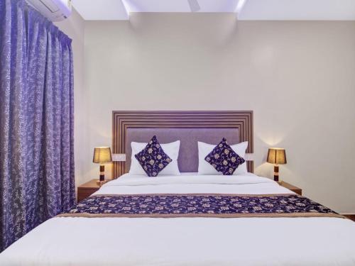a bedroom with a large bed with purple curtains at THE SUPERB HOTEL PVT LTD in Hyderabad
