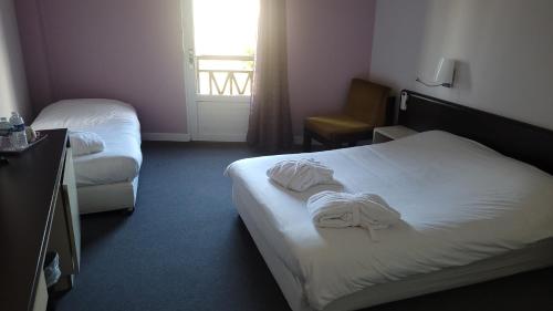 una camera d'albergo con due letti e una finestra di La Truffière a Puy-lʼÉvêque