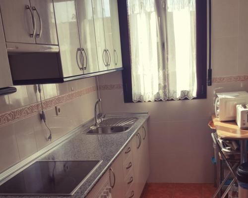 cocina con fregadero y ventana en Villa Yolita, en Sepúlveda