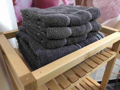 a pile of gray towels on a wooden rack at Willkommen im Casa Felice, der Wohlfühl Oase mit Balkon, 4 Betten und Homeoffice Platz in Aidlingen