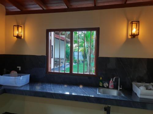 w kuchni z umywalką i oknem w obiekcie Hansa Villa w mieście Hikkaduwa