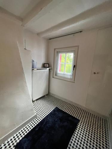 an empty room with a window and a tiled floor at Noah - Seeleben auf Zeit am Rursee in Rurberg