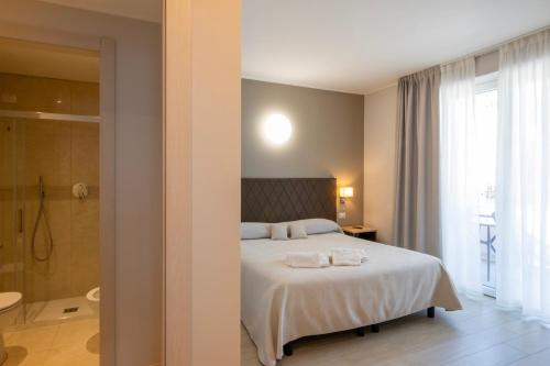 a bedroom with a bed and a bathroom with a shower at Hotel Boston in Stresa
