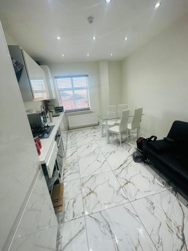 a kitchen with white marble floors and a table and chairs at KNIGHTSBRIDGE COURT in Horninglow