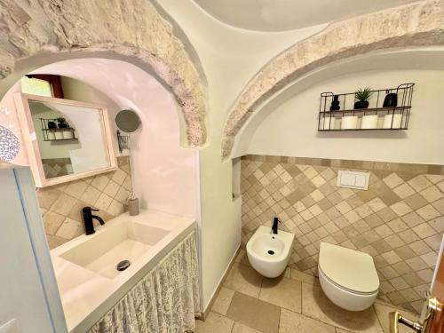 a bathroom with a tub and a toilet and a sink at Trulli Moon in Alberobello