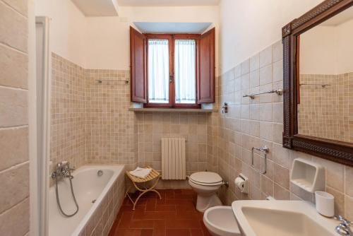 a bathroom with a tub and a toilet and a sink at Villa Colombaio in Siena