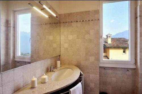 baño con lavabo, espejo y ventana en La Bella Ossuccio, en Ossuccio