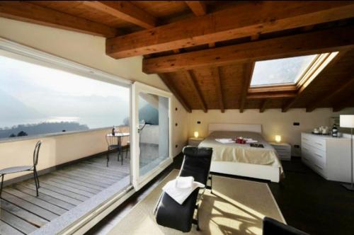 1 dormitorio con 1 cama y balcón con vistas. en La Bella Ossuccio, en Ossuccio