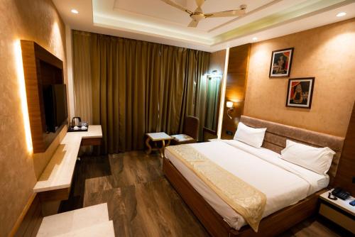 um quarto de hotel com uma cama e uma televisão em Hotel RR 62 em Jaipur