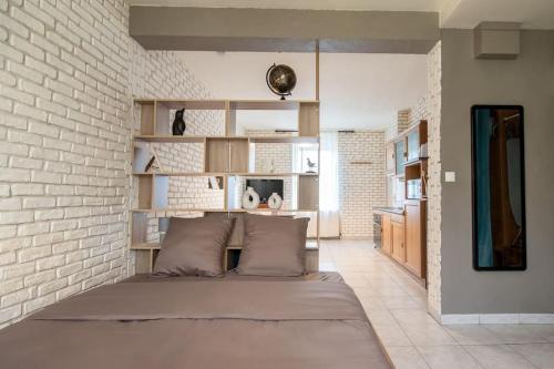 a large bed in a room with a brick wall at Le Graphite in Auboué
