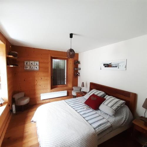 une chambre avec un lit avec un oreiller rouge dessus dans l'établissement Appartement Chamonix Bossons, à Chamonix-Mont-Blanc