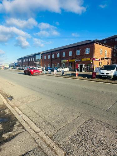 an empty street with cars parked in front of a building at KNIGHTSBRIDGE COURT in Horninglow