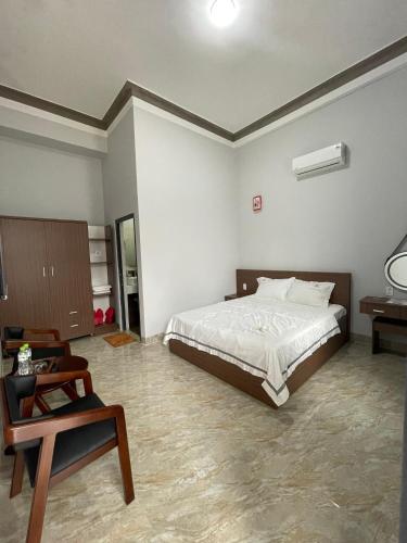 een slaapkamer met een bed, een tafel en een stoel bij Nam Anh Hotel in Bao Loc