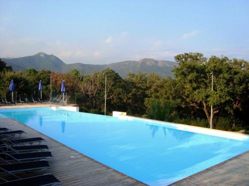 サント・リュシ・ド・ポルト・ヴェッキオにあるRésidence Odalys San Martinuの山々を背景にした青い大型スイミングプール